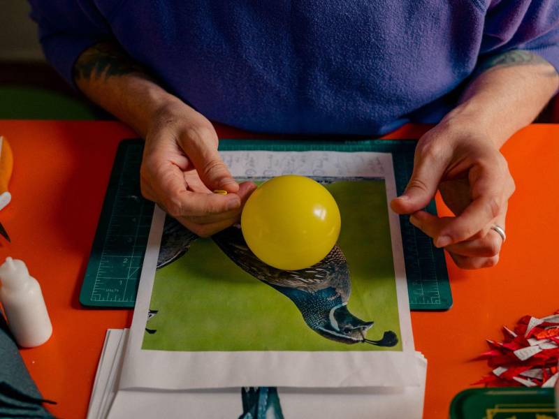 Roberto Benavidez inicia su proceso de creación de piñatas envolviendo pequeños globos con tiras de papel maché.