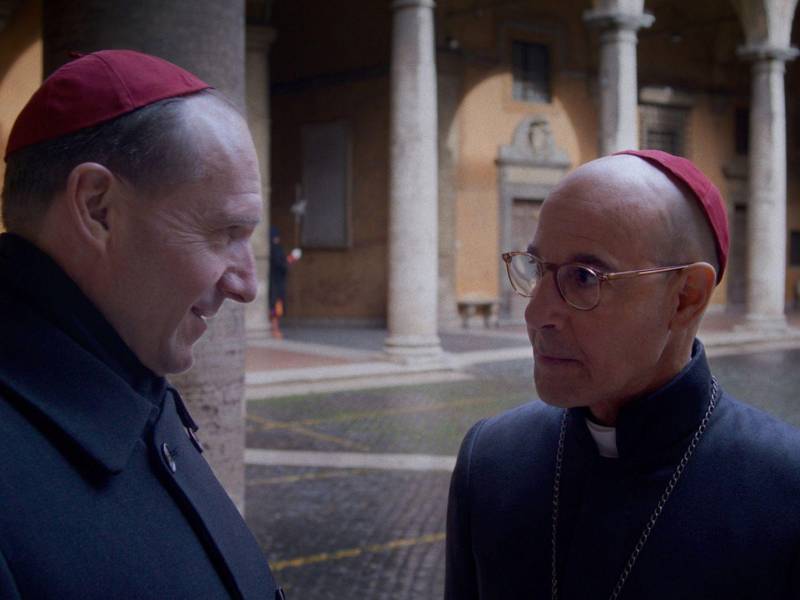 Ralph Fiennes (izq.) y Stanley Tucci interpretan a Cardenales de un bloque progresivo en “Cónclave”.