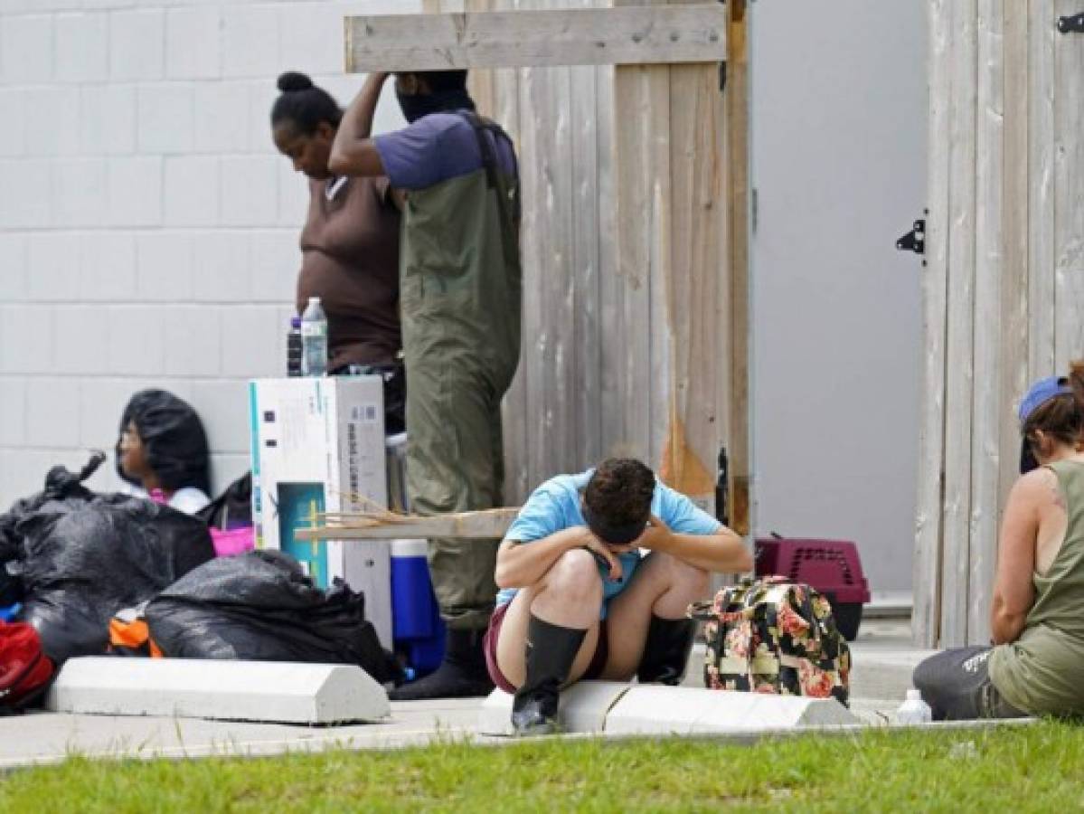 People who were rescued from rising floodwaters wait for transportation in the aftermath of Hurricane Ida in LaPlace, La., Monday, Aug. 30, 2021. (AP Photo/Gerald Herbert)