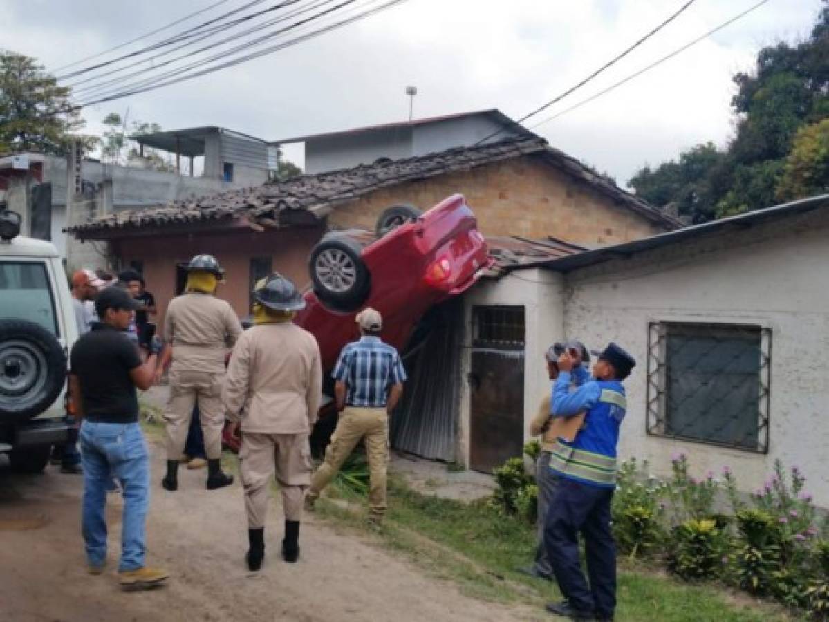 Mujer se vuelca en su vehículo y queda sobre una casa en Santa Rosa de Copán