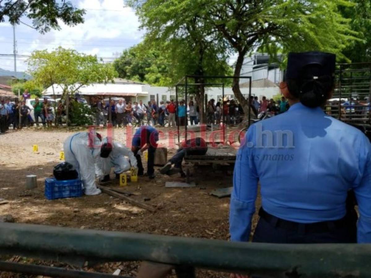 Una oficial de la Policía Nacional observa cuando agentes de la DPI recogen evidencias en la escena del crimen. Foto: Gissella Rodríguez/El Heraldo.