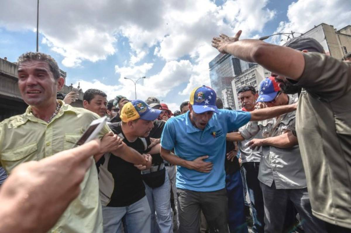 Así reaccionaba Capriles en una de las protestas al inhalar gas lacrimógeno. (Agencias/AFP)