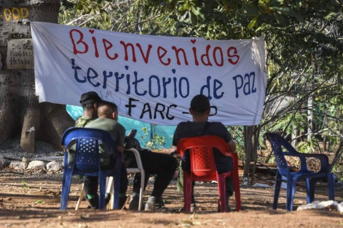 Members of the FARC leftist guerrilla rest at the entrance to the area where the rebels are gathering in the municipality of San Jose de Oriente, Cesar department, northern Colombia on February 28, 2017.The initial phase of the FARC disarmament process, which includes making an inventory of weapons and destroying unstable munitions, begins on March 1 according to the timetable agreed in the peace pact between the rebels and the government in November 2016. / AFP PHOTO / Luis Acosta