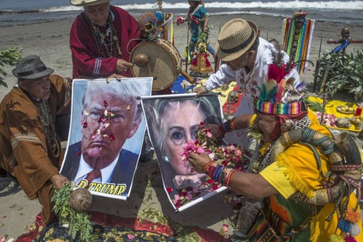 Son siete chamanes y una chamana que lanzan pétalos de flores y escriben 'EEUU' con granos de maíz sobre un trozo de tela. Foto: AFP