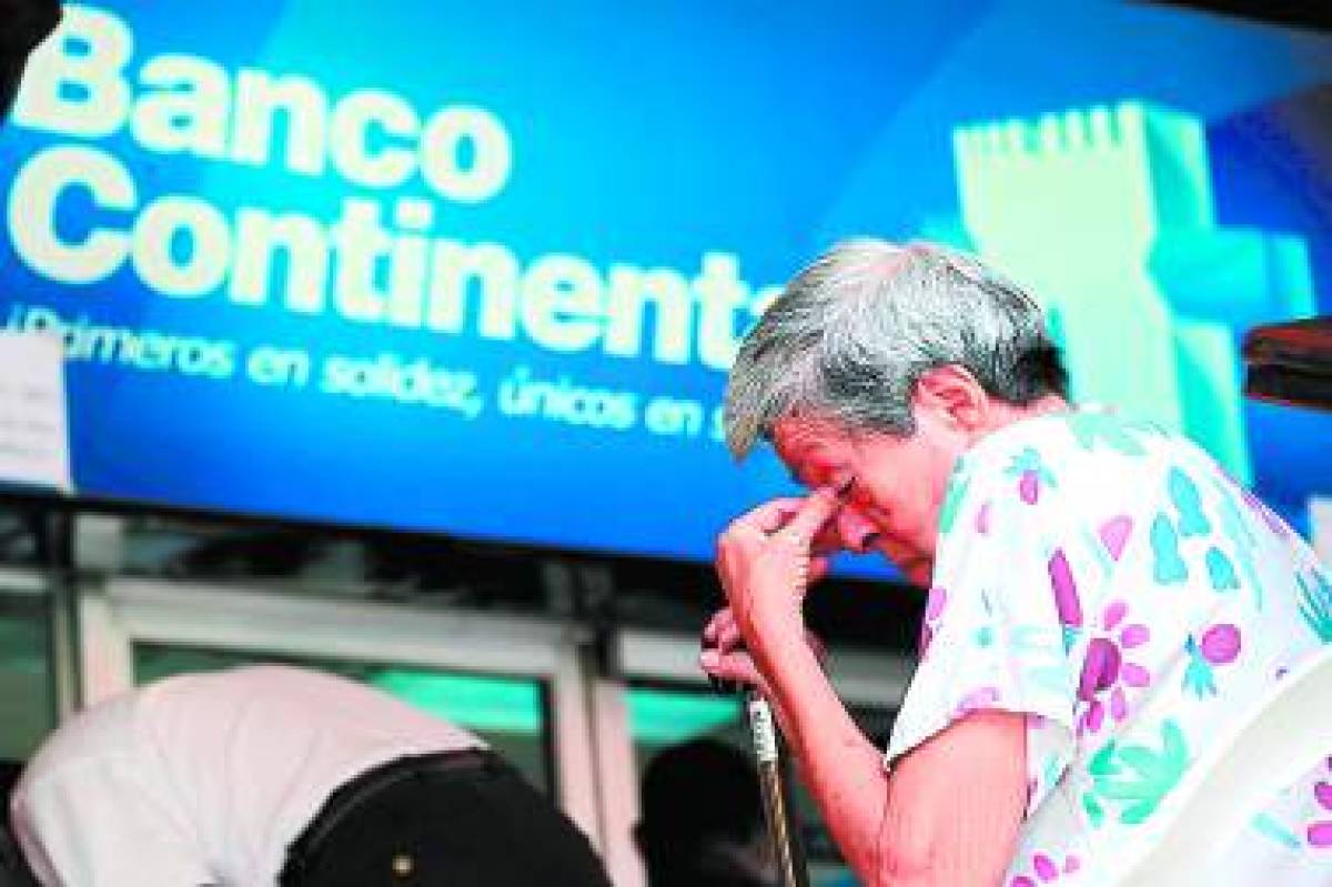 A saver cries at the head office of the Continental Bank in Tegucigalpa, Honduras, on October 12, 2015. The government announced they will warrant deposits of about 220.000 savers for amounts up to 9.000 US Dollars. The Continental Bank was shuted down by the goverment after the US accusations of money laundry linked with drug trafficking. AFP PHOTO / Orlando SIERRA