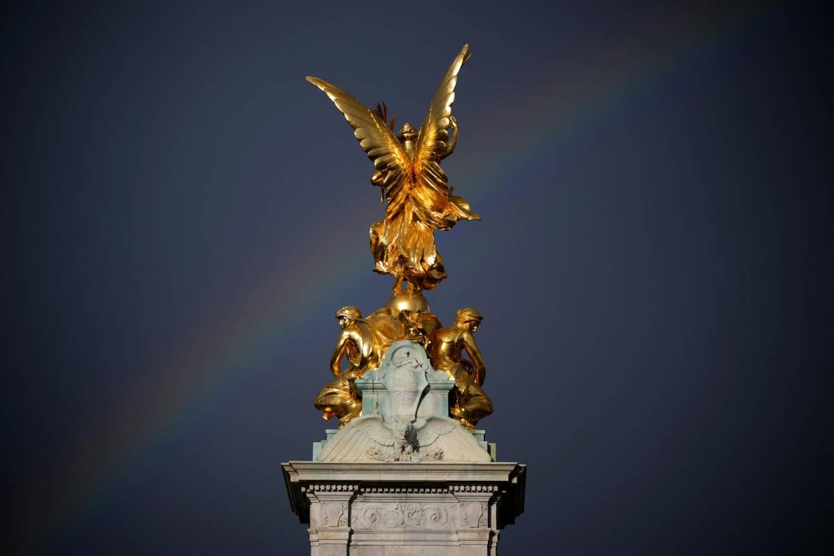 Un arcoíris se ve en el memorial de la reina Victoria, al lado opuesto del Palacio de Buckingham.