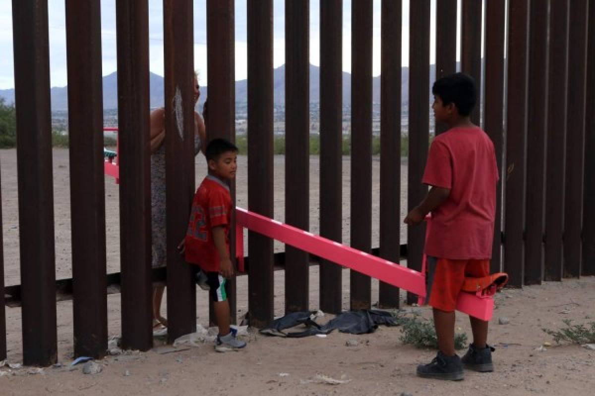 Un grupo de niños mexicanos juega con un juguete llamado 'arriba y abajo' (See-Saws) sobre la frontera mexicana con Estados Unidos en la zona de Anapra en Ciudad Juárez. Foto: Agencia AFP