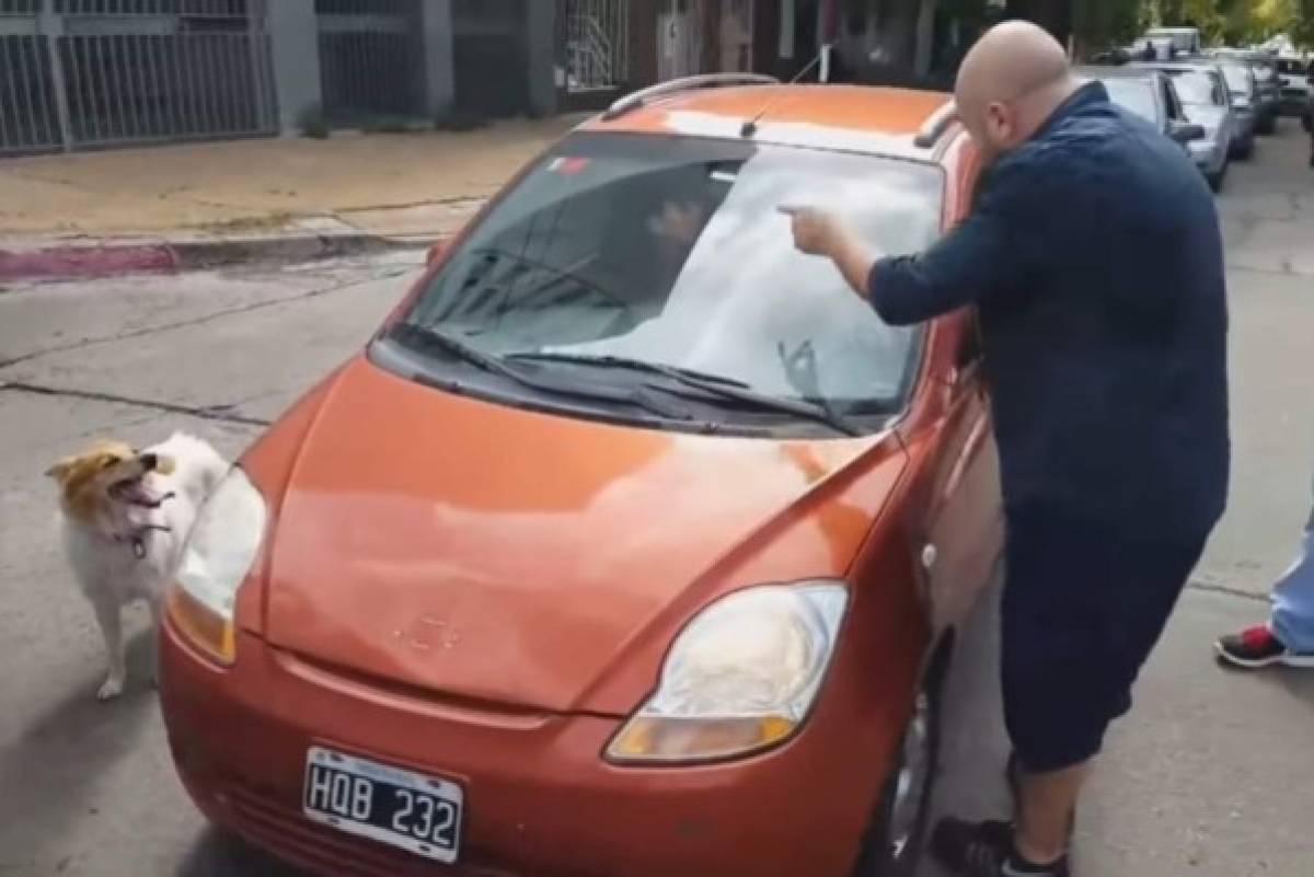 El hombre le reclama a la mujer fuertemente y la amenaza en no dejarla pasar hasta que suba al perro al carro.