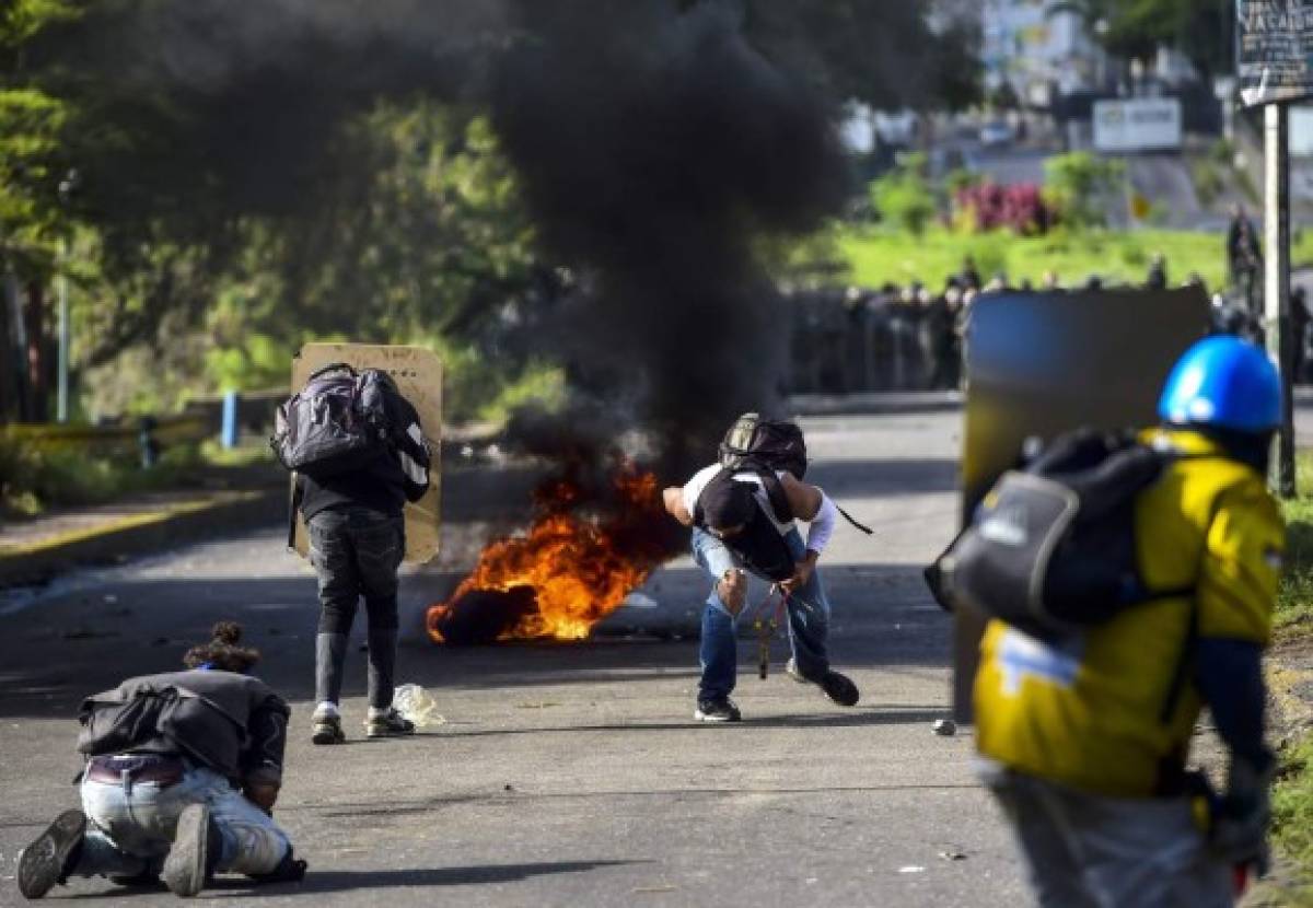 Anti-government activists skirmish with riot police during a protest against the election of a Constituent Assembly proposed by Venezuelan President Nicolas Maduro, in Caracas on July 30, 2017.Deadly violence erupted around the controversial vote, with a candidate to the all-powerful body being elected shot dead and troops firing weapons to clear protesters in Caracas and elsewhere. / AFP PHOTO / RONALDO SCHEMIDT