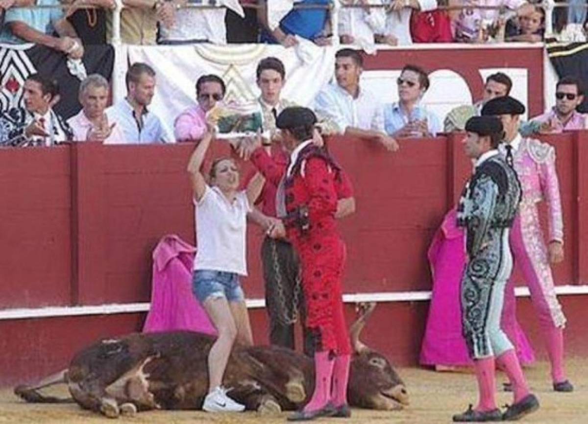 Mujer consuela a un toro moribundo