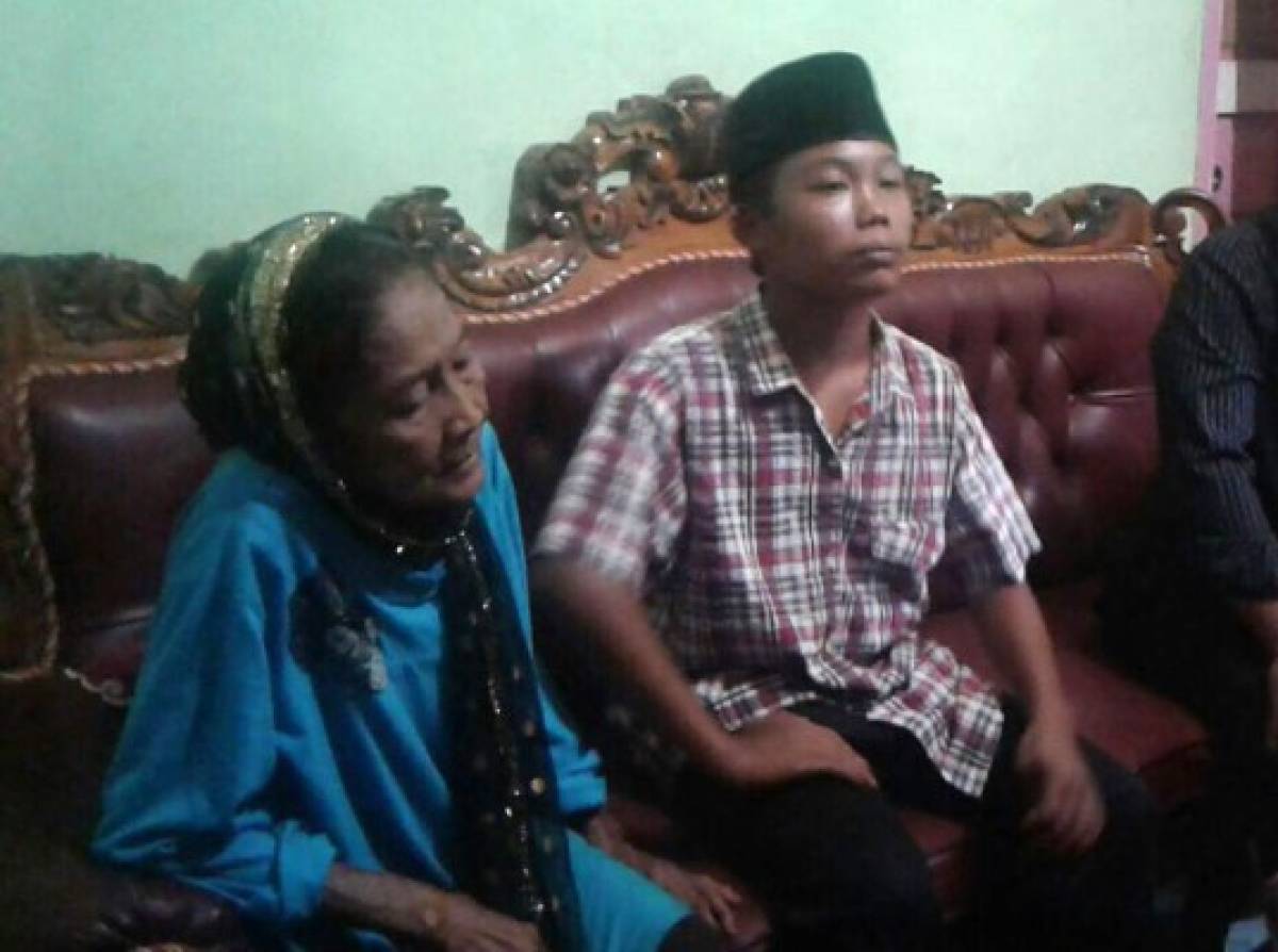 This undated recent photograph shows 73-year-old Rohaya binti Kiagus Muhammad Jakfar (L) sitting with her 15-year-old teenage husband Selamet Riyadi (R) in Baturaja, South Sumatra province.The controversial marriage took place in a remote village of Karang Endah in South Sumatra province on July 2, 2017, the village chief told AFP. The romance between the lovebirds began to bloom five months ago when Rohaya binti Kiagus Muhammad Jakfar took care of neighbour Selamet Riyadi, 15, who suffered from malaria. / AFP PHOTO / STR