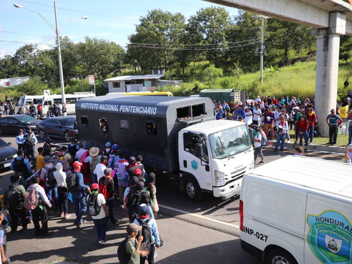 Con maleta en mano y niños en brazos, hondureños caminan por protesta en carretera CA-5