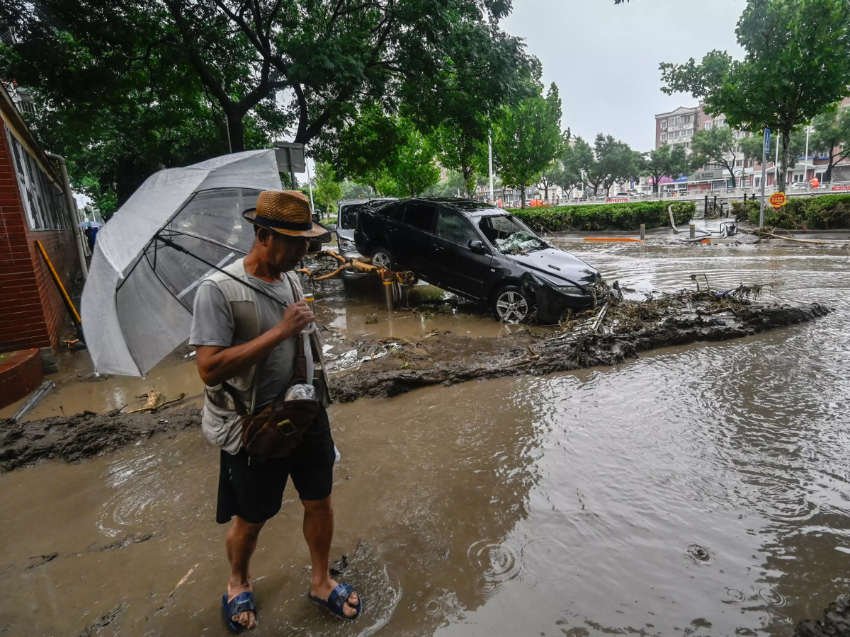 Automóvil arrastrado por las inundaciones provocadas por las lluvias torrenciales en Pekín.