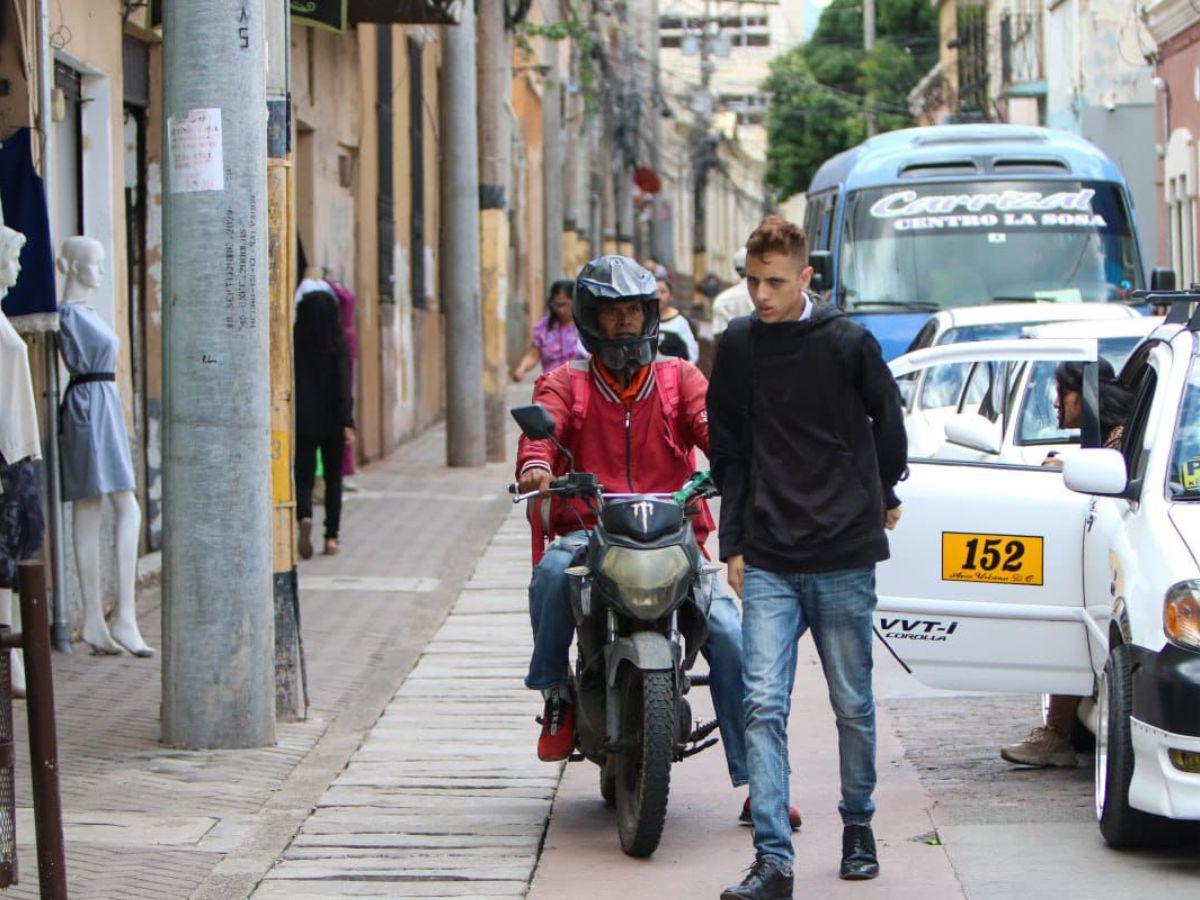 Solo se requiere esperar pocos minutos para presenciar el desconocimiento del nuevo espacio para peatones y ciclistas, la gráfica muestra a un motociclista molesto por un peatón aunque él conduce por el tramo de la ciclovía.