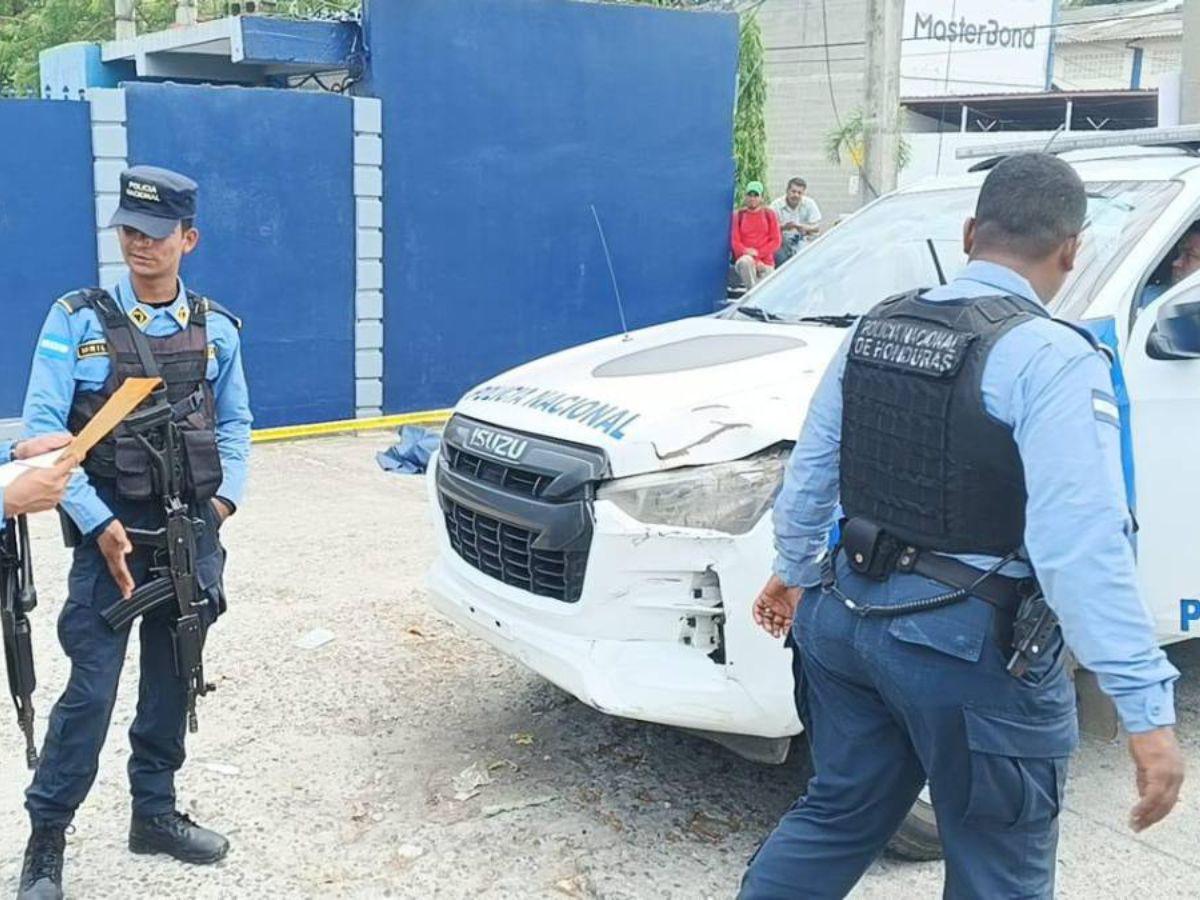 Policías resguardan la escena del crimen, frente a la entrada de una residencial y a una fábrica.