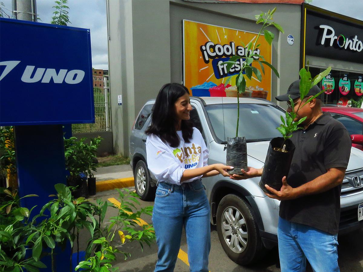 <i>Clientes de UNO recibiendo sus árboles frutales de parte de voluntarios, quienes también ofrecieron consejos sobre cómo plantarlos y cuidarlos adecuadamente.</i>