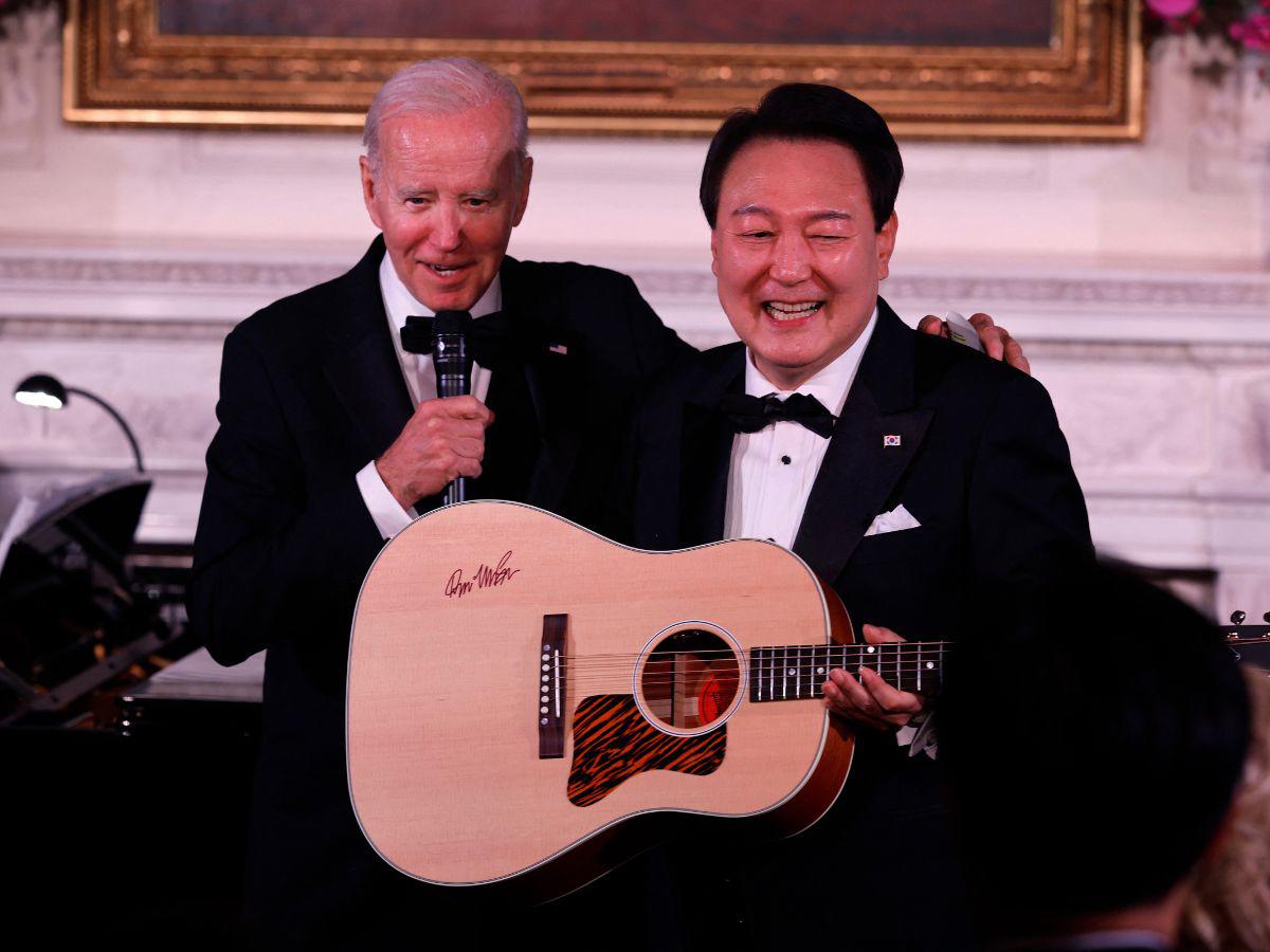 Momento en que Biden le entrega la guitarra autografiada.