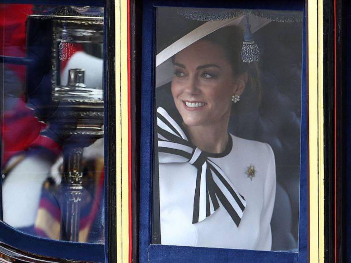 Lucía un vestido blanco, tacones a juego y un gran sombrero blanco y negro, irradiando elegancia y estilo.