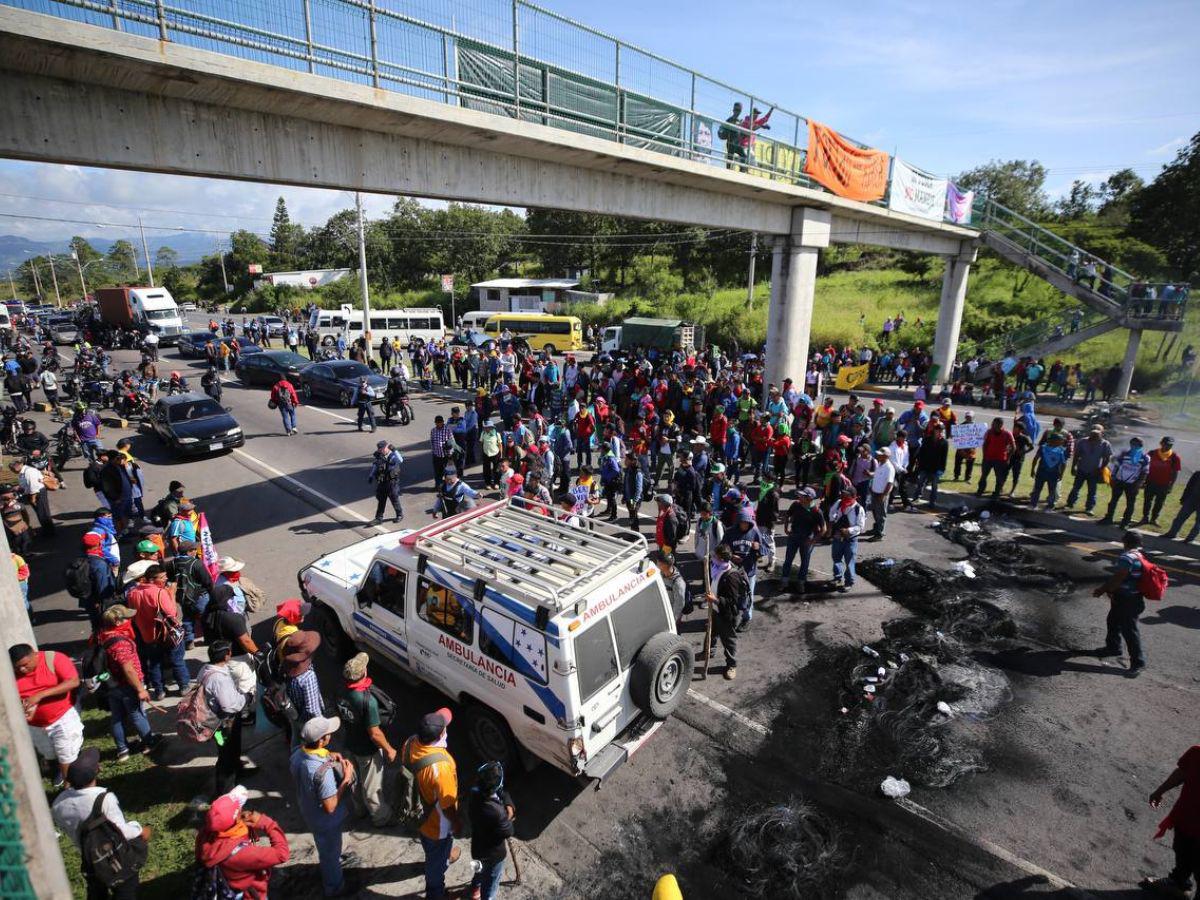 Con maleta en mano y niños en brazos, hondureños caminan por protesta en carretera CA-5