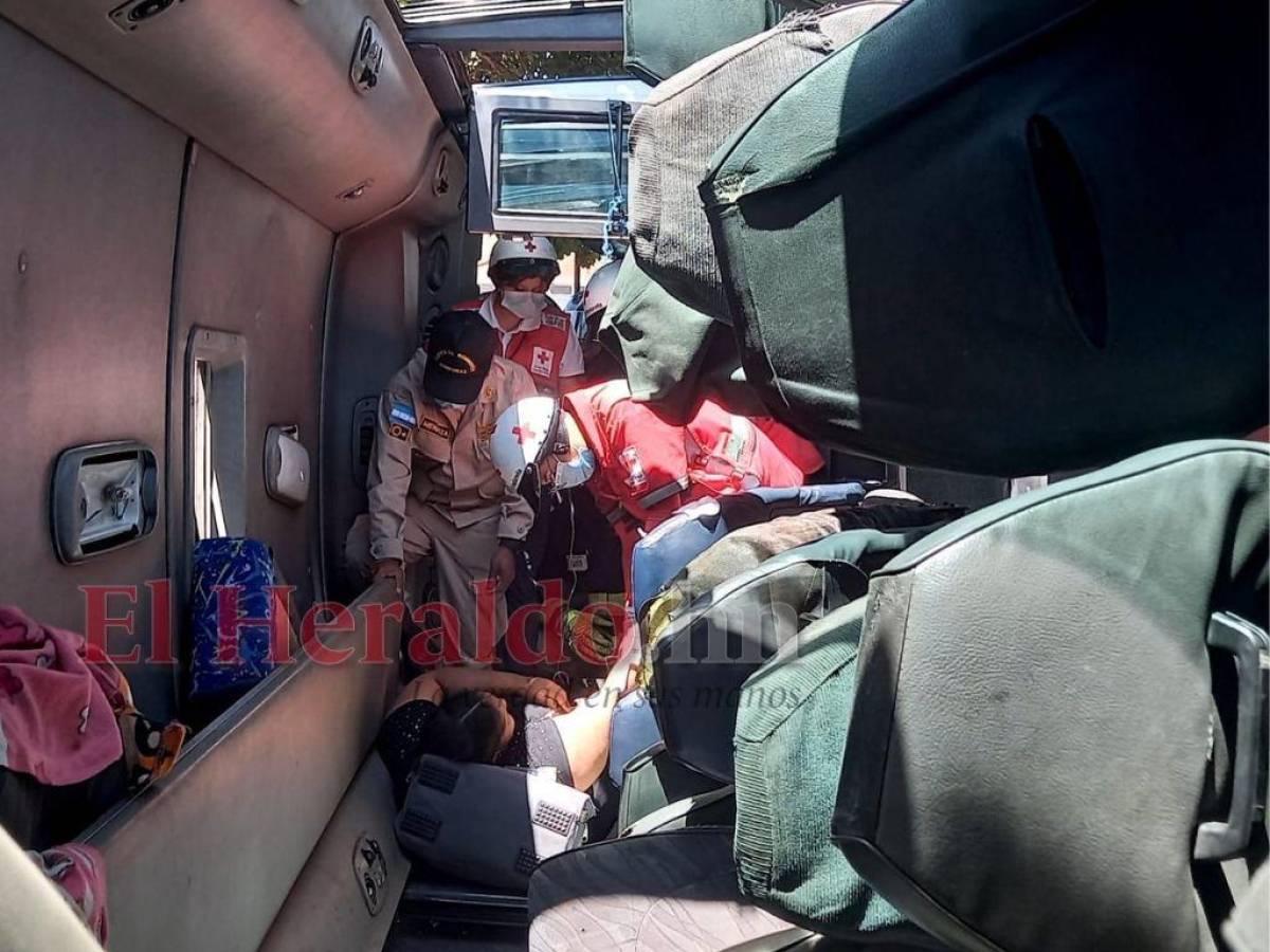 Momento en que el Cuerpo de Bomberos rescata a una fémina que quedó atrapada en unas de las unidades.