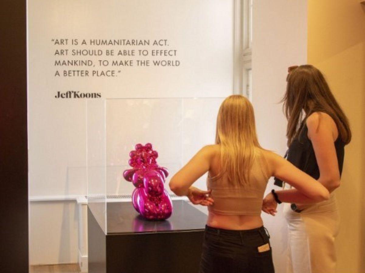 Dos jóvenes aprecian una de las obras de arte de Koons.