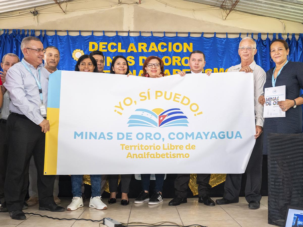 <i>Una ceremonia oficial donde se declara a un municipio libre de analfabetismo, un hito en la lucha por la educación.</i>