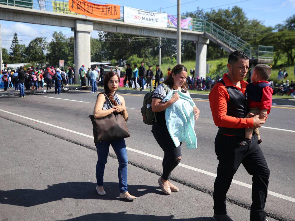 Con maleta en mano y niños en brazos, hondureños caminan por protesta en carretera CA-5