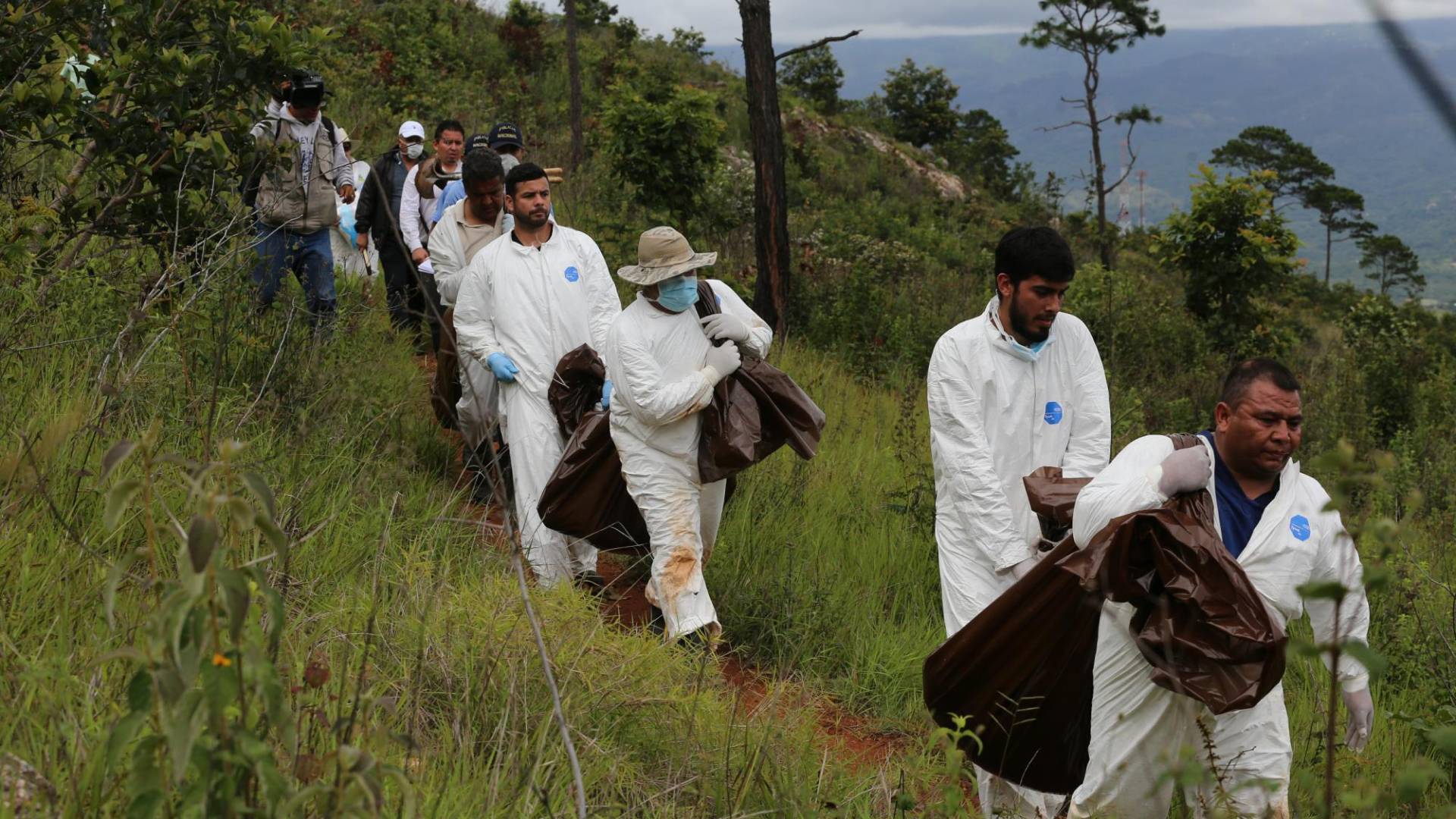 $!Cuando los cadáveres son enterrados en zonas montañosas, las autoridades deben -en muchos casos- cargar los cuerpos hasta donde están los vehículos.