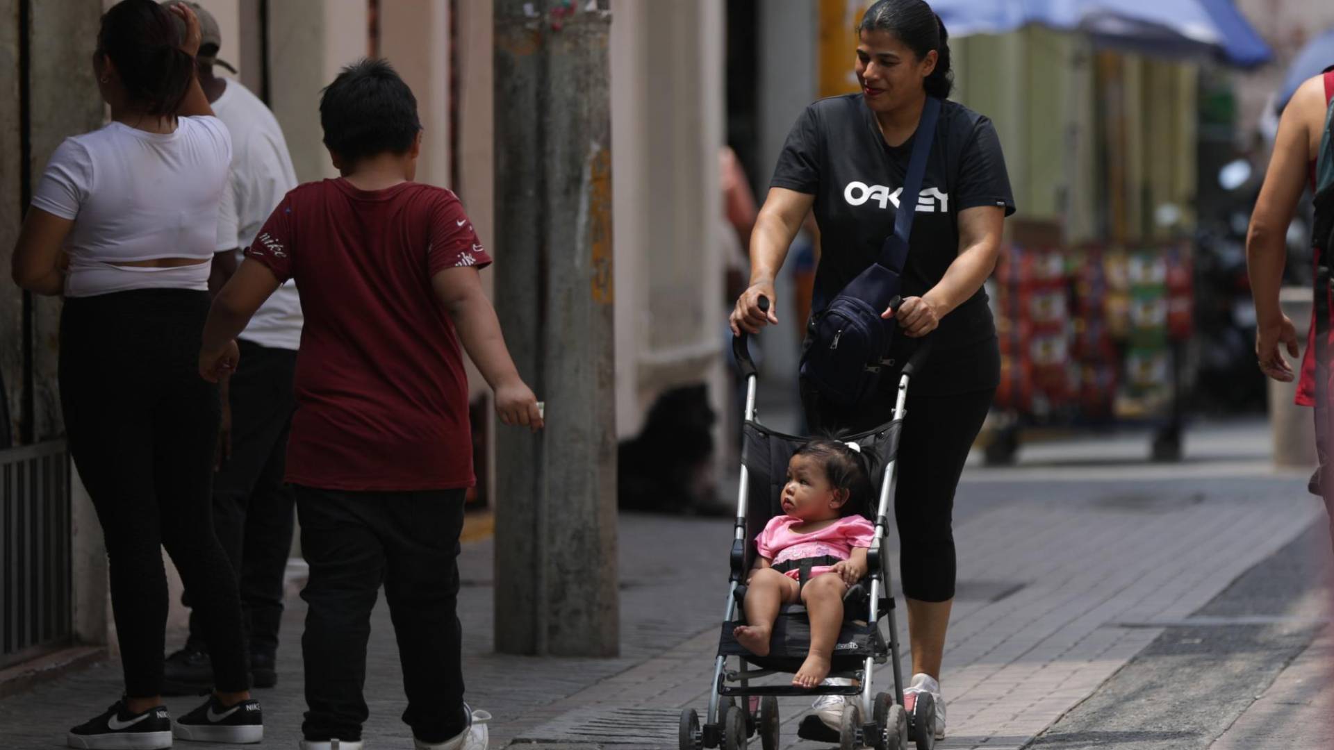 $!Una madre pasea en una carriola a su hija en el Parque Central capitalino. Este segundo domingo de mayo se celebra el Día de las Madres en Honduras.