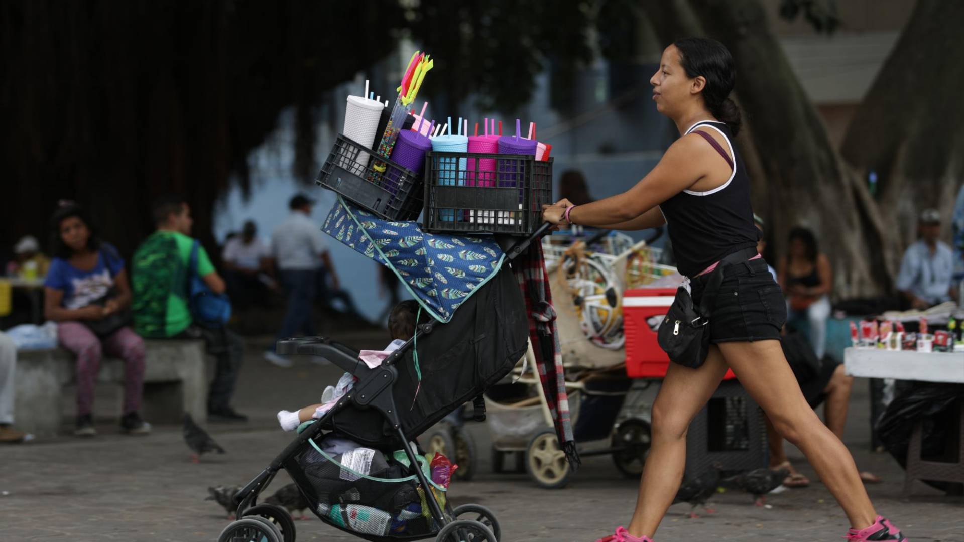 $!Yeimi Ávila vende vasos de plástico todos los días en el Parque Central. En un pequeño coche camina a su bebé de 10 meses.