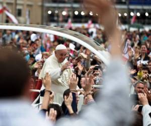 Pope Francis is driven through the crowd in St. Peter's Square at the Vatican, Sunday, April 27, 2014. Pope Francis has declared his two predecessors John XXIII and John Paul II saints in an unprecedented canonization ceremony made even more historic by the presence of retired Pope Benedict XVI. (AP Photo/Vadim Ghirda)