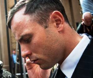 Atleta paralímpico sudafricano Oscar Pistorius habla por su teléfono móvil mientras abandona la Hight Court Pretoria después de su audiencia de sentencia el 13 de octubre de 2014 .