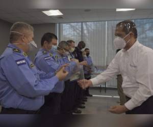 El momento en que uno de los ejecutivos de Grupo Ficohsa hacía entrega de las máscaras a algunos agentes policiales.