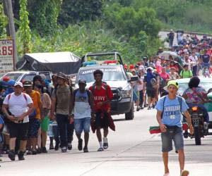 Migrantes caminan en caravana este sábado rumbo a Estados Unidos, en el municipio de Tapachula en Chiapas.