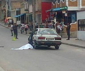 El cuerpo del taxista quedó tendido a un costado de la unidad que conducía. (Foto: Estalin Irías)