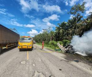 Miembros del Cuerpo de Bomberos llegaron para apagar las llamas que estaban consumiendo la rastra después de colisionar con un camión cargado de productos de abarrotería en la carretera CA-13.