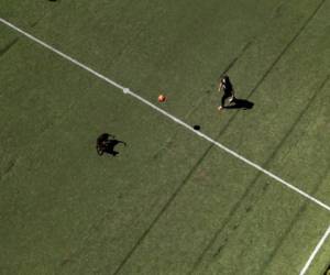 Milagros Espínola juega con su perro en una cancha de fútbol en Asunción, Paraguay, el viernes 17 de abril de 2020.