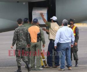 Personal de la Agencia de Regulación Sanitaria (Arsa), del Programa Ampliado de Inmunizaciones (PAI) y de la Administración Aduanera de Honduras fueron los encargados de descargar las cajas de la aeronave. Foto Johny Magallanes| EL HERALDO