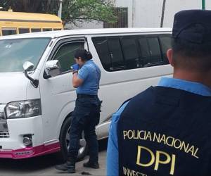 Agentes de la Dirección Policial de Investigaciones (DPI) inspeccionan la unidad de transporte que recibió varios impactos de bala esta tarde en la capital.