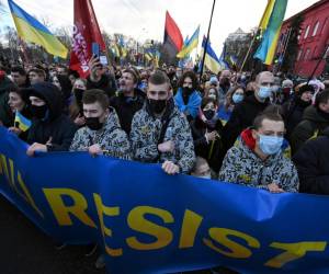 Los manifestantes gritan consignas mientras marchan detrás de una pancarta que dice “Los ucranianos resistirán” con los colores de la bandera nacional durante una manifestación en Kiev el 12 de febrero de 2022, realizada para mostrar unidad en medio de las advertencias de Estados Unidos sobre una inminente invasión rusa.