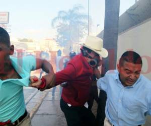 El expresidente Manuel Zelaya salió corriendo de la protesta luego que un miembro de la Policía Militar le lanzara una bomba lacrimógena. Foto: AP