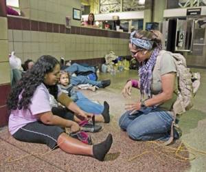 La hondureña Doris Suyapa sujeta sus zapatos con cuerda amarilla en la terminal de buses de Greyhound en Phoenix, Arizona.