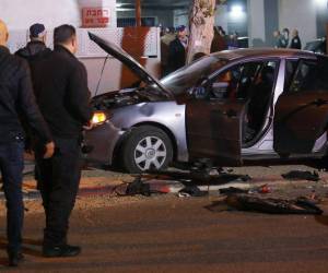 Las fuerzas de seguridad israelíes se reúnen en el lugar de un ataque que dejó dos policías israelíes muertos en la ciudad norteña de Hadera el 27 de marzo de 2022.