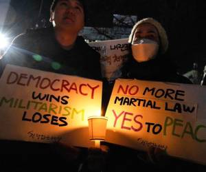 Miembros de la Confederación de Sindicatos de Corea (KCTU) y grupos cívicos sostienen carteles y velas durante una manifestación que piden el despido y el proceso de destitución del presidente de Corea del Sur.