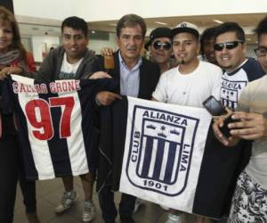 El entrenador del equipo hondureño fue recibido por los hinchas peruanos en el aeropuerto. Foto: Líbero.