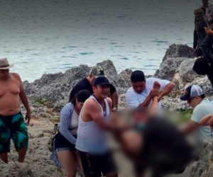 Momento en que otros bañistas y rescatistas sacaban del agua el cuerpo del turista.