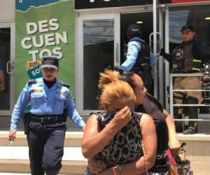 Momento en el que la Policía llevaba resguardada a una de las integrantes de la banda de asaltantes en San Pedro Sula. (Foto: @RedInformativaH)