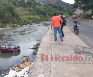 La doctora cayó con su vehículo fuera de control desde este muro de unos cinco metros de altura y quedó en medio de la corriente. Foto y video: Estalin Irías/EL HERALDO.