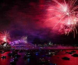 Fuegos artificiales iluminan el Puente del Puerto y la Ópera en una espectacular bienvenida al 2025.