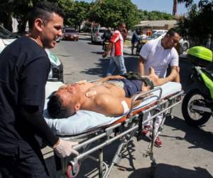 Los socorristas llevan a un oficial de policía herido en un atentado con bomba en una comisaría de policía en Barranquilla, Colombia. Foto AFP